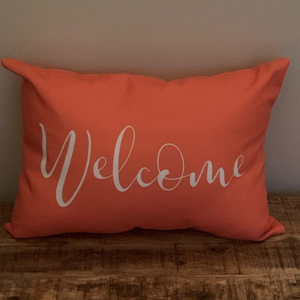 Decorative orange Welcome pillow.